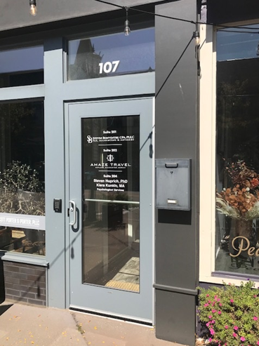 Storefront entrance with engraved glass address and business names.